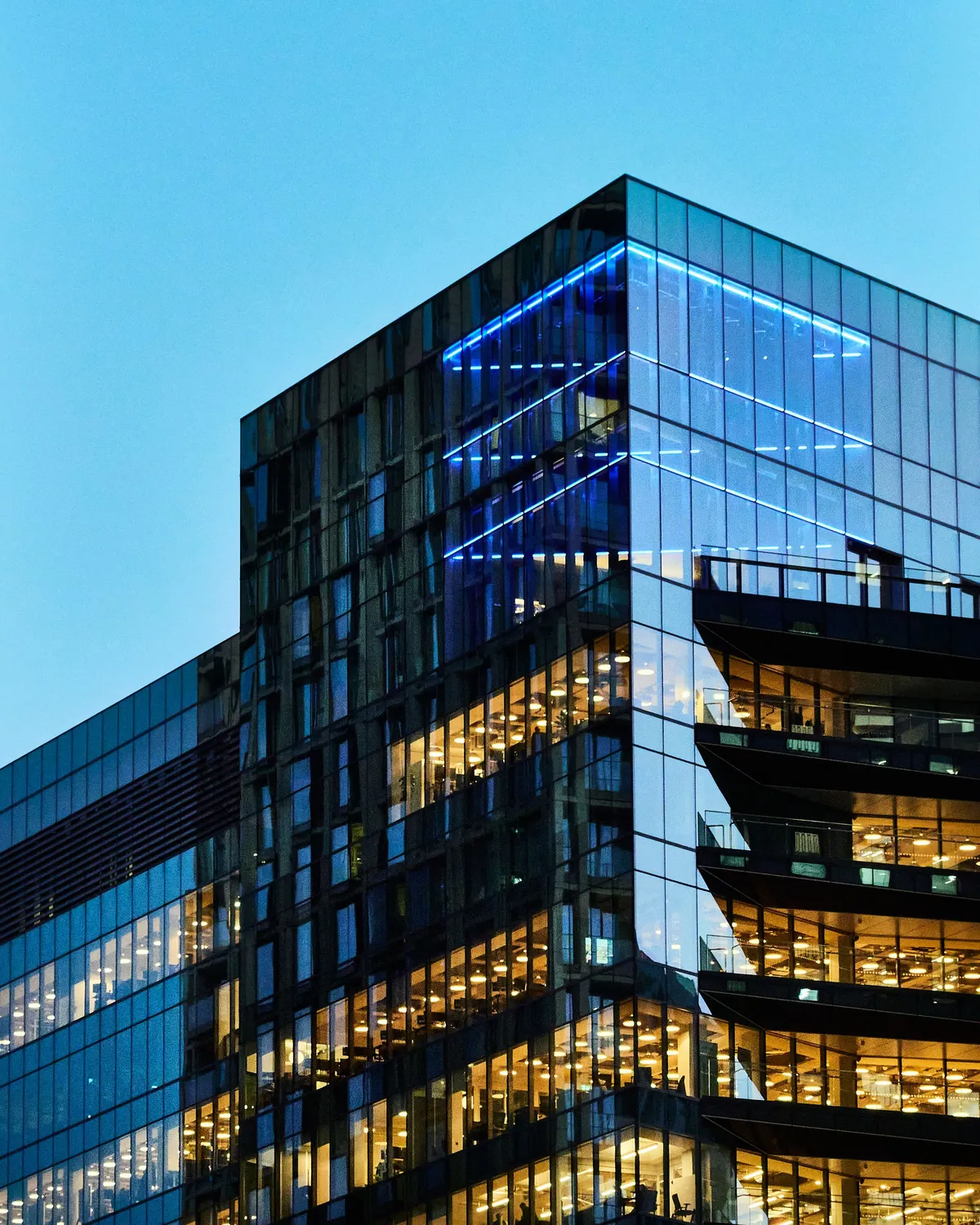 Glass building at twilight with lit interior floors